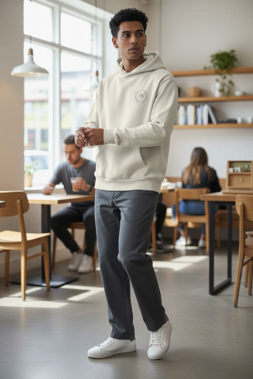 Justice Wear Collective cream heavyweight fleece hoodie with oversized fit, two-panel hood, and kangaroo pocket.